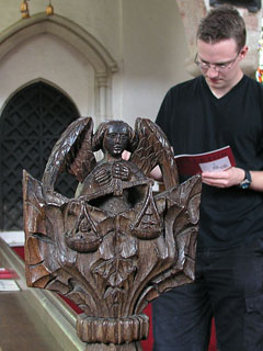 St Michael weighs souls on a bench-end as Ben writes notes.